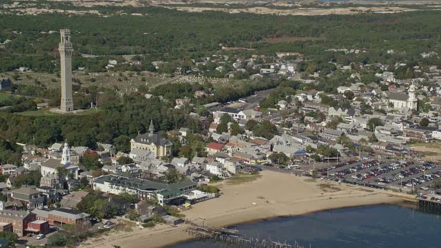 Aerial view of a tower on the hill of a small coastal town