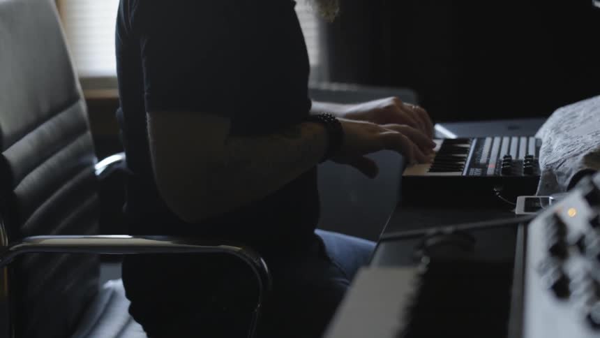 A man is playing an electronic keyboard