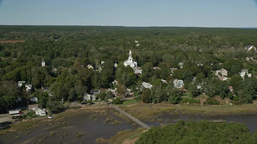 A white church in a rural town covered in forests