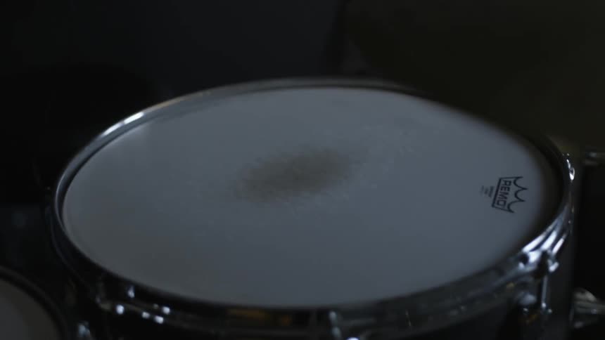 A man puts earbuds on a drum