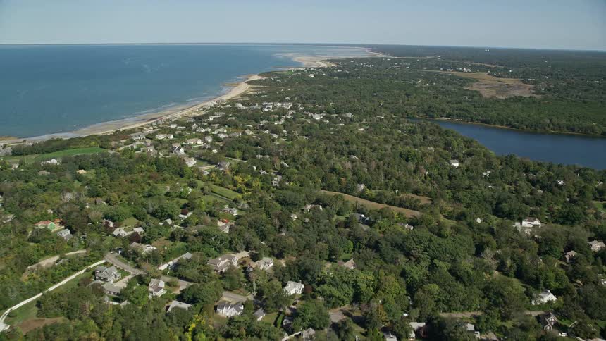 Aerial view of a coastal town in a rural area and a lake near the ocean