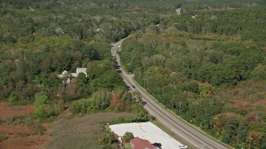 Aerial view of cars driving on a road through the countryside