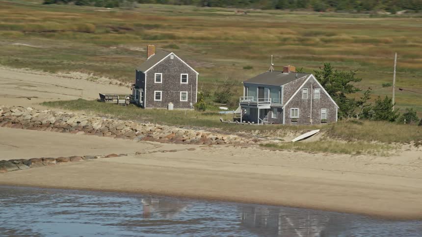 Shallow water reflects two houses built near the beach