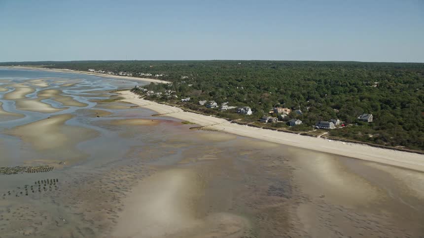 A beach area with a dry sea and just a few pools of water on the sand