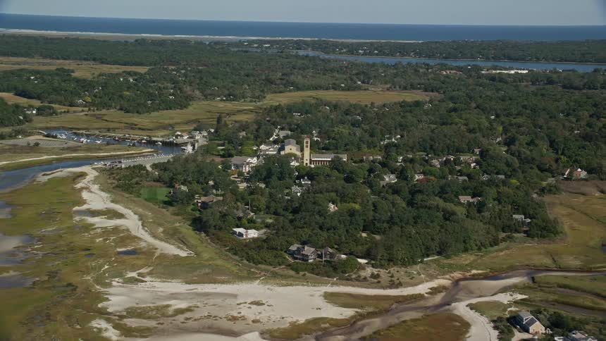 Aerial view of sand banks on the coast next to a town