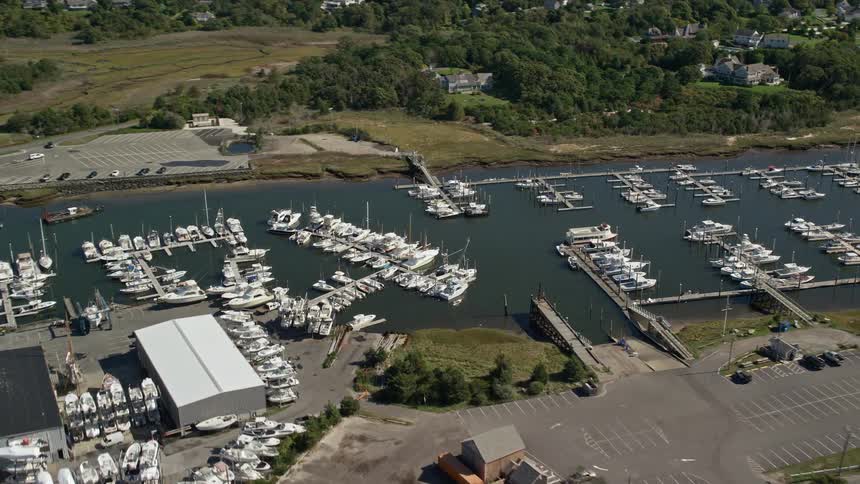 Aerial view of boats on a marina next to a coastal town