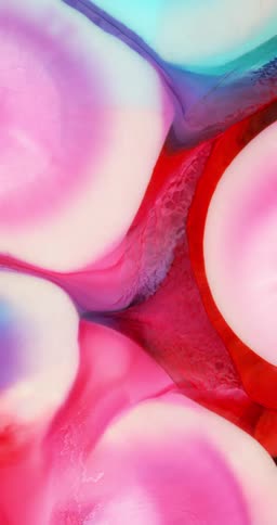 Colorful inks mixing into an abstract pattern in vertical direction