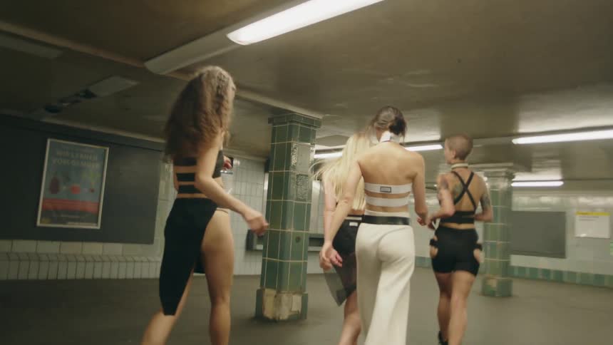 Small group of friends in fashion clothes running and smiling on a train station