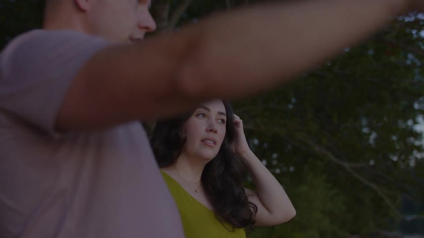 Man and woman stand outdoors holding a discussion