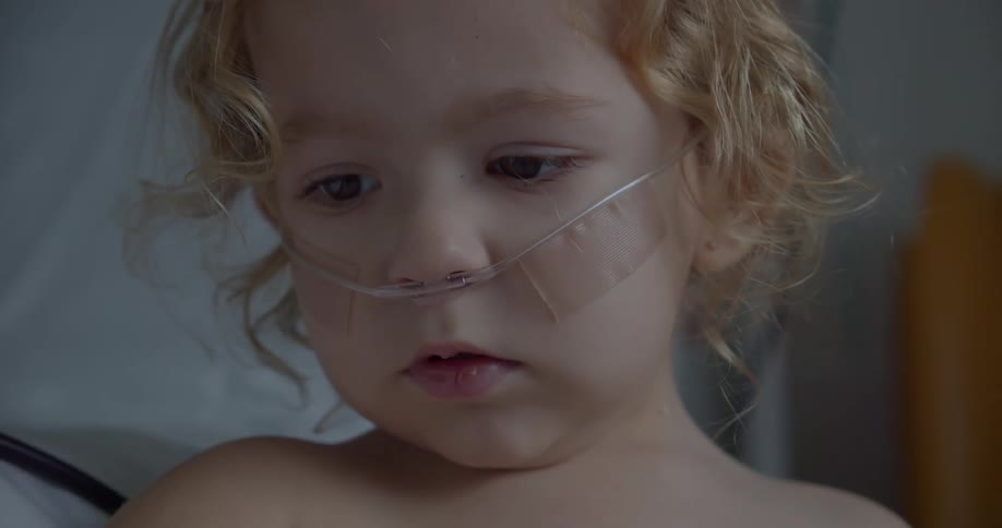 A young girl with a breathing tube in her nose