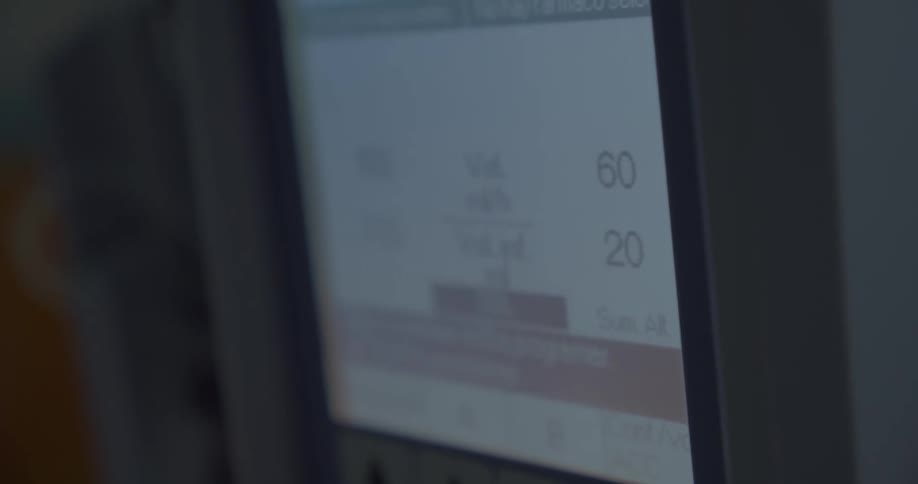 A screen showing volumes and numbers in a low light room