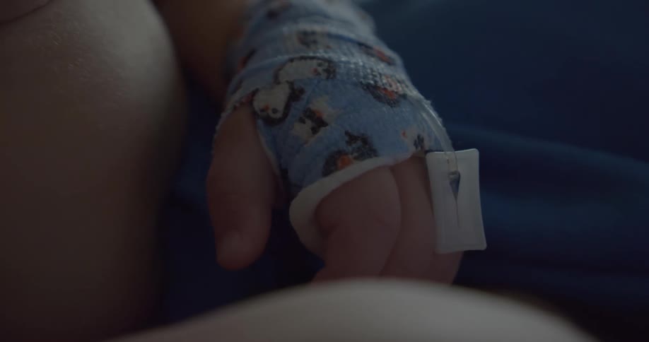 Close up of babys hand with a blue glove