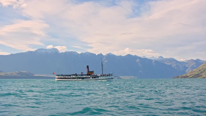 Tourist boat on Lake Wakatipu with the Remarkables mountain range on the horizon