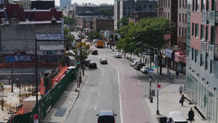Panorama of a city with people walking and cars moving during the day