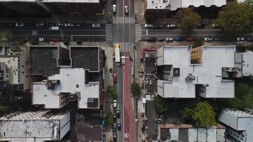 An intersection of streets with some cars passing by in a suburban area