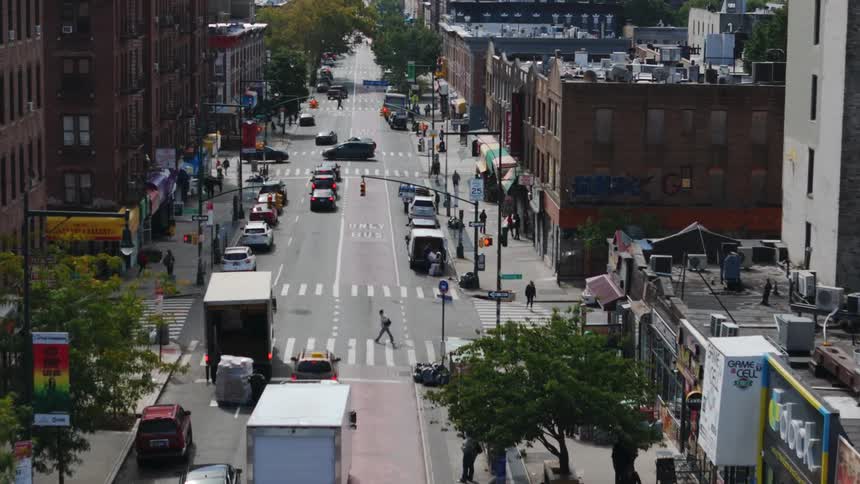 Aerial of moving cars on a city street at midday