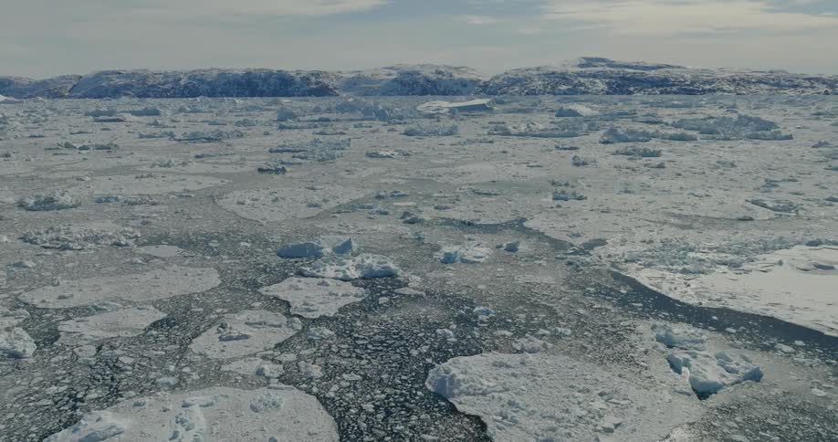 An arctic region with the ground covered in pieces of ice and snow