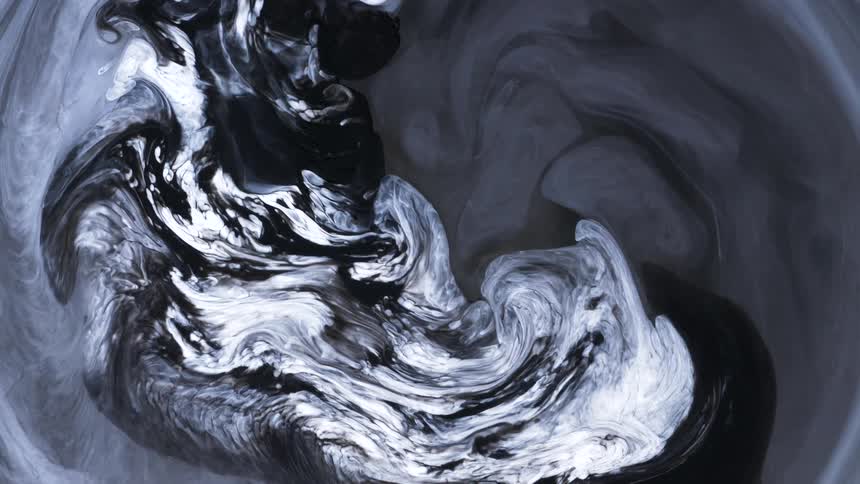 Black and white ink swirling together slowly mixing into gray