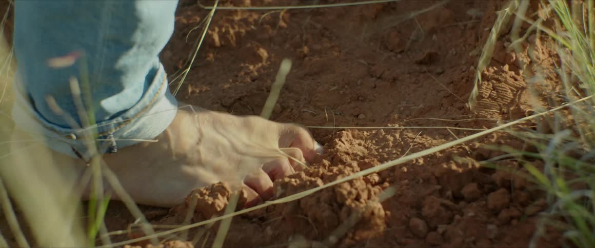 A closeup of a mans bare feet walking in the dirt