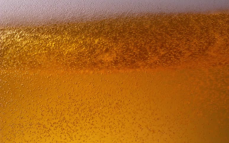 S a closeup of bubbles in a glass of beer