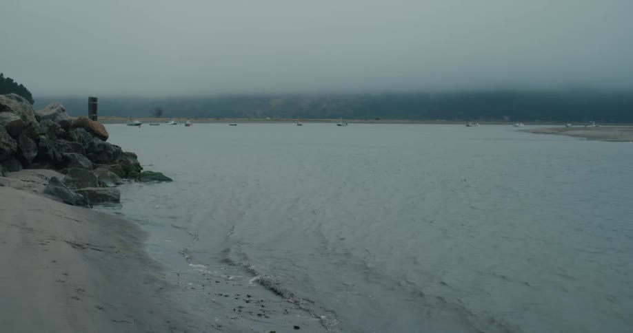 Seaside with mountains covered in fog