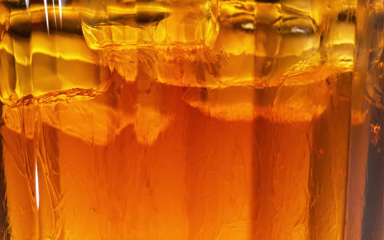 Ice cubes melt on a drink inside a glass