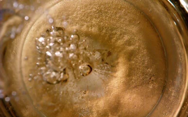 Closeup of a glass of water with bubbles rising to the surface