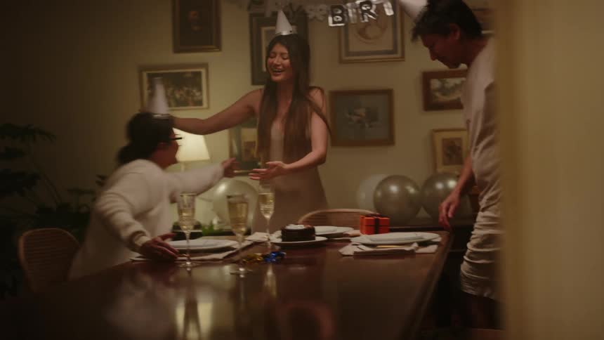 Dad and mom embrace their daughter as they celebrate her birthday