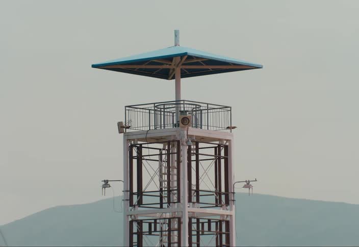 Small observation tower in an open field during the day