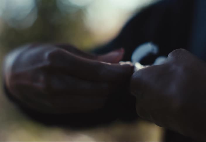 Closeup of a womans hands adjusting her hearing aids