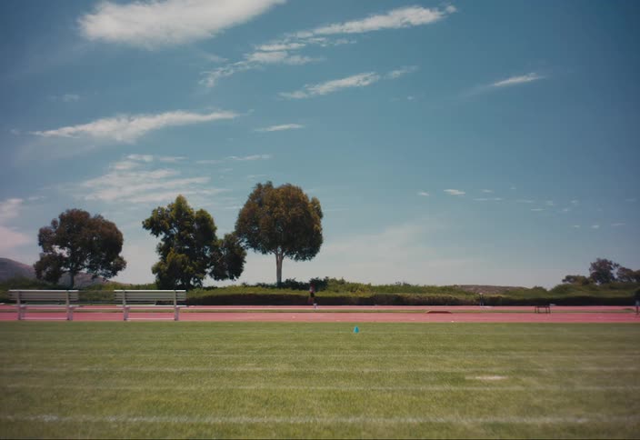 Woman running on an athletics track on a sunny day