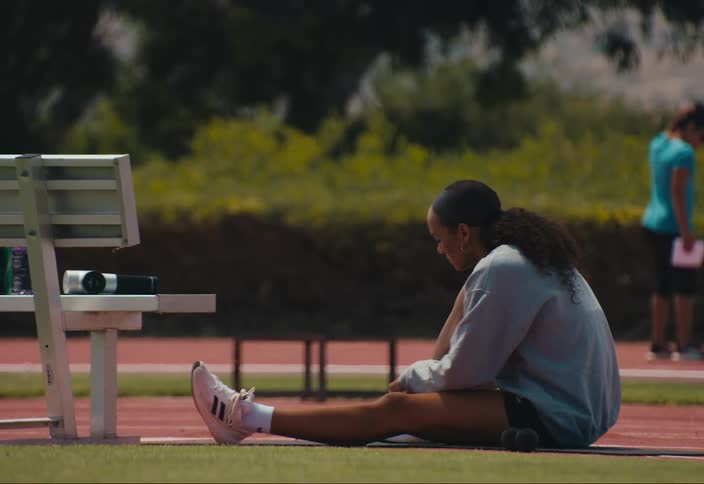 Athlete ties her shoes on the track