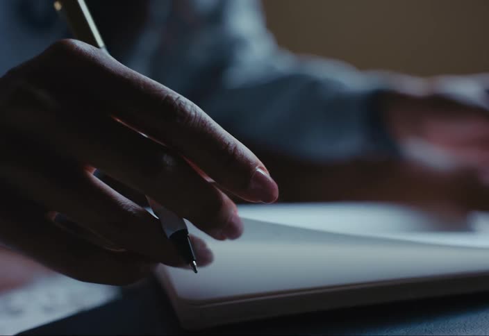 A woman is writing in a journal