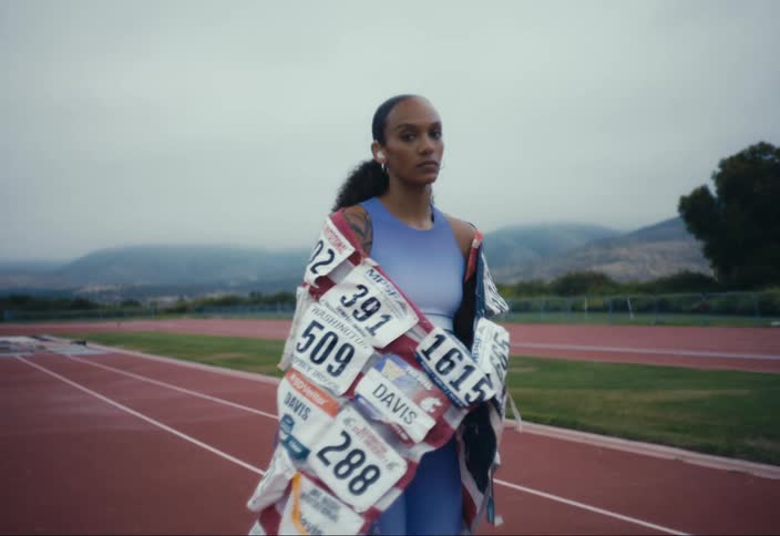 Portrait of an athlete wearing hearing aids and a flag made of race bibs
