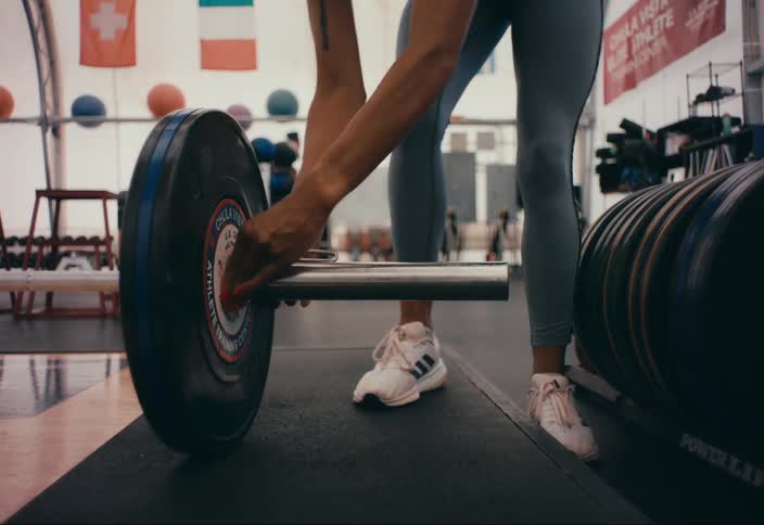A woman prepares for a workout in the gym