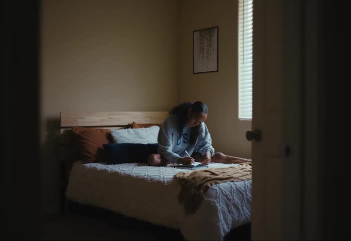 A young woman writes in a journal
