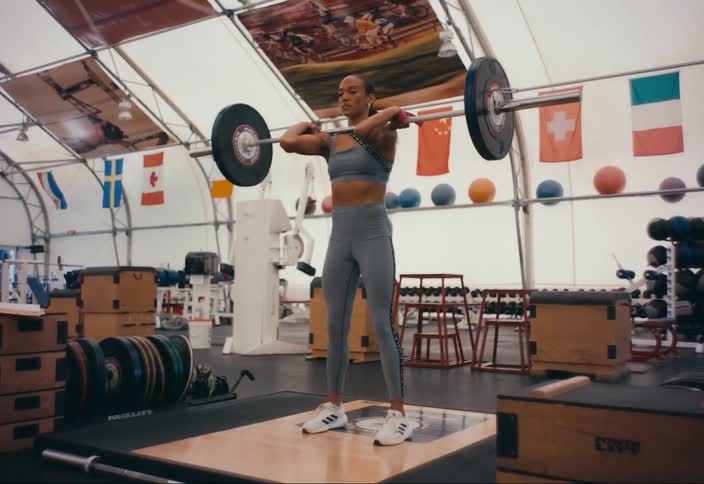 An athlete lifts weights in a gym