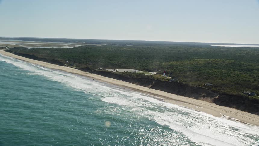 A coastal region of a land with vegetation facing the blue sea