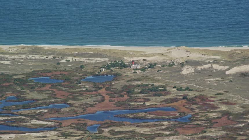 Road leads to building located between lakes and beach