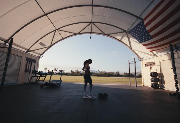 A woman standing in an empty gym