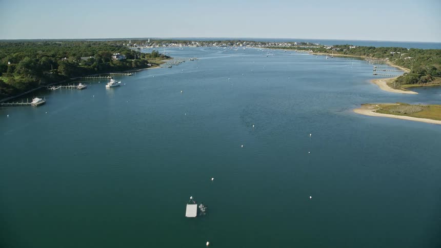 Aerail view of a large body of water surrounded by trees boats in the water and houses on the shore