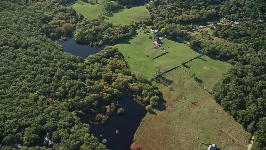 Aerial panorama of a natural area with a few residential buildings among the trees and lakes
