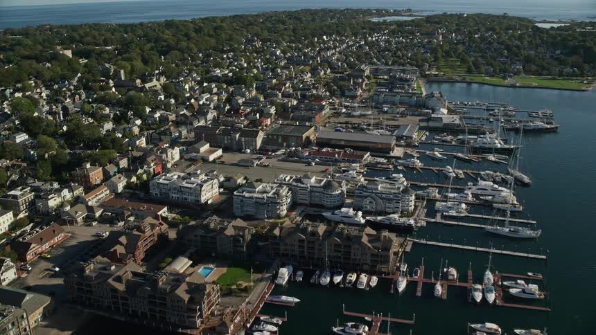 Boats sit at dock on edge of coastal town bordering forest