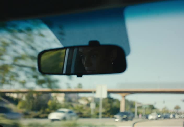 From the front windshield of a car the road is visible as other cars drive by