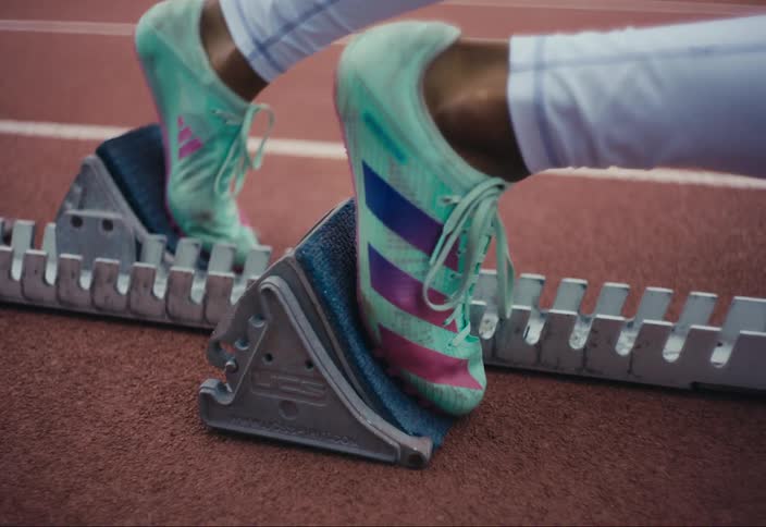 Closeup of a person placing their feet on the starting blocks of a race