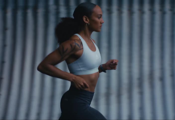 A woman runs down a road through a tunnel