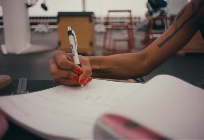 Woman writes in notebook at table in gym