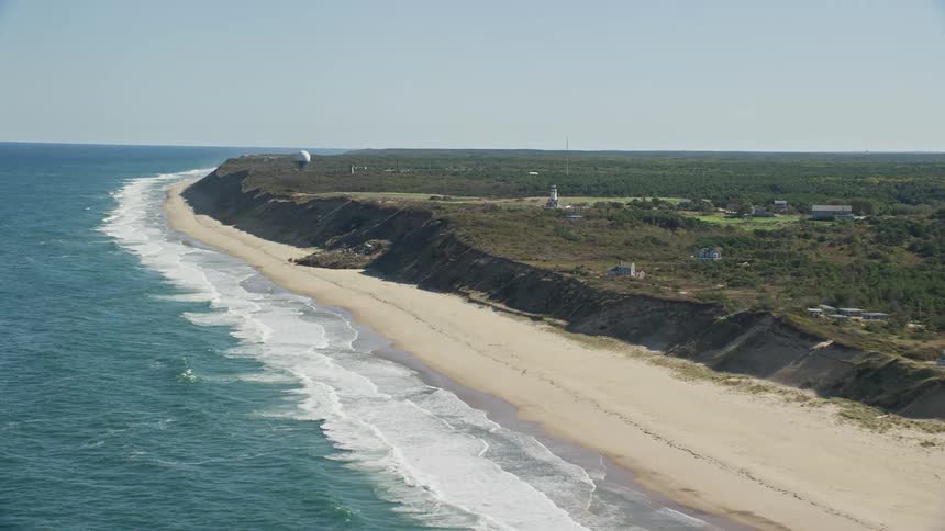 Aerial view of ocean waves breaking against the long beach