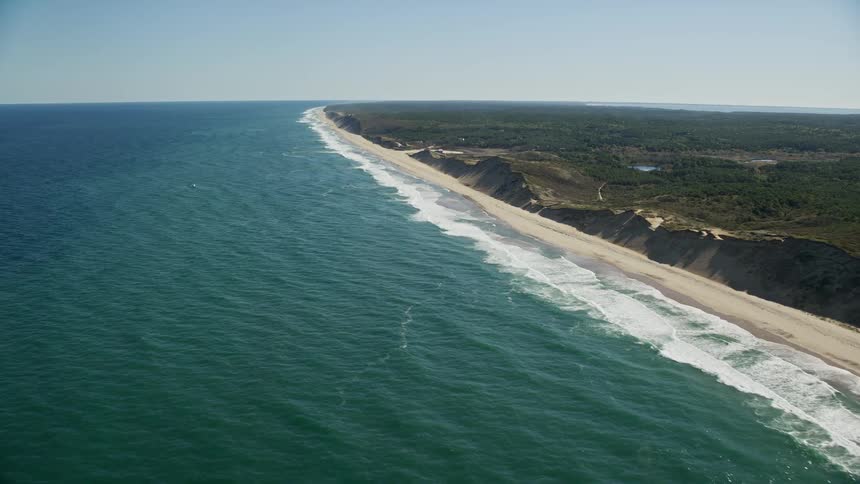 Waves crash against the shore of the island
