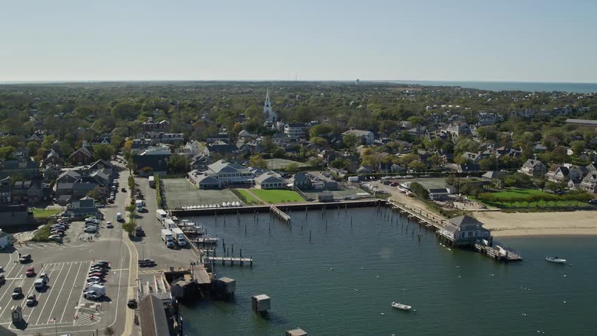 Vehicles move through wooded coastal town to and from docks